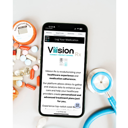 Orange, white, and clear pills sit next to a phone displaying the Viiision Rx platform. A teal stethoscope also rests next to the phone.